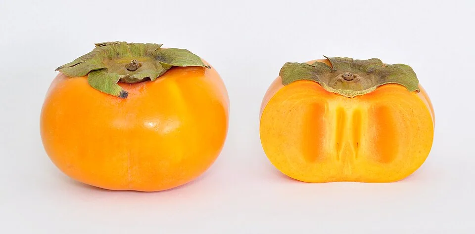 Kakis (Diospyros kaki) : un fruit entier et un fruit coupé